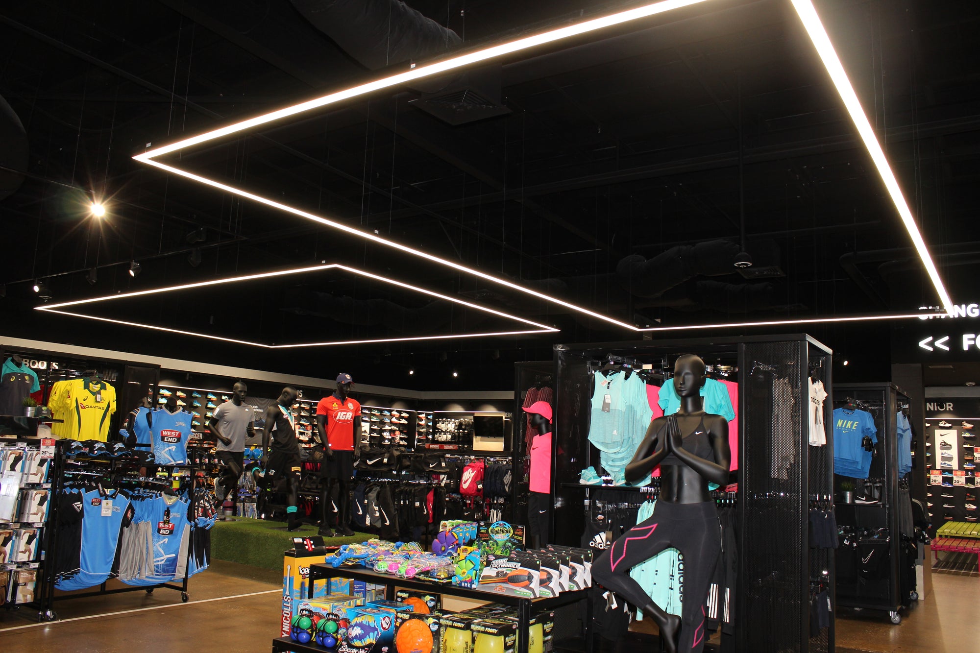 Zorich Group SportsPower store interior with mannequins and clothing displays under bright lights.
